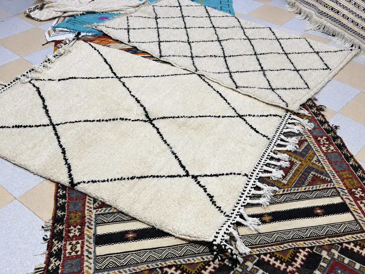 Layered handwoven rugs filling the frame with color, pattern, and texture