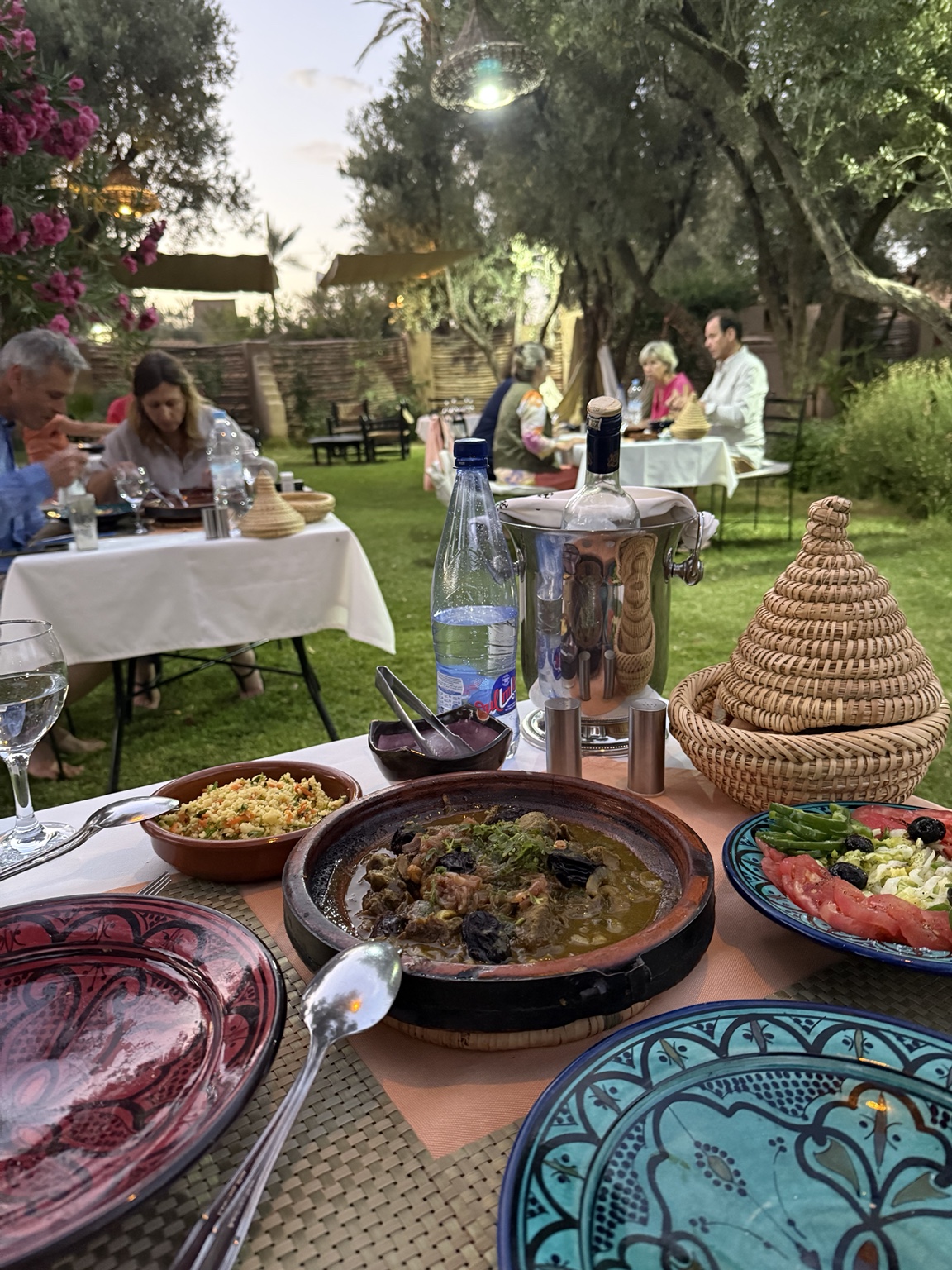 A colorful Moroccan dinner served outdoors beneath olive trees